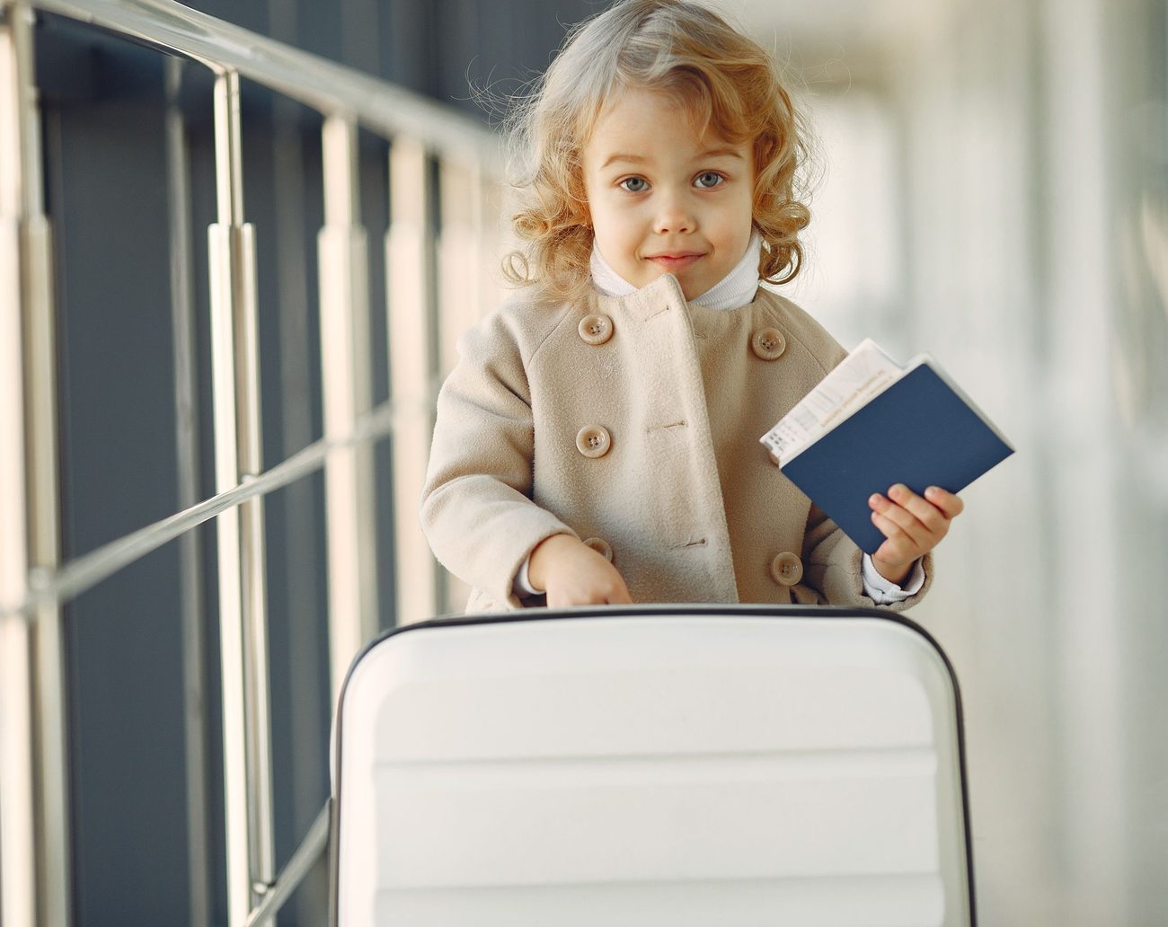 Niña con pasaporte y valija